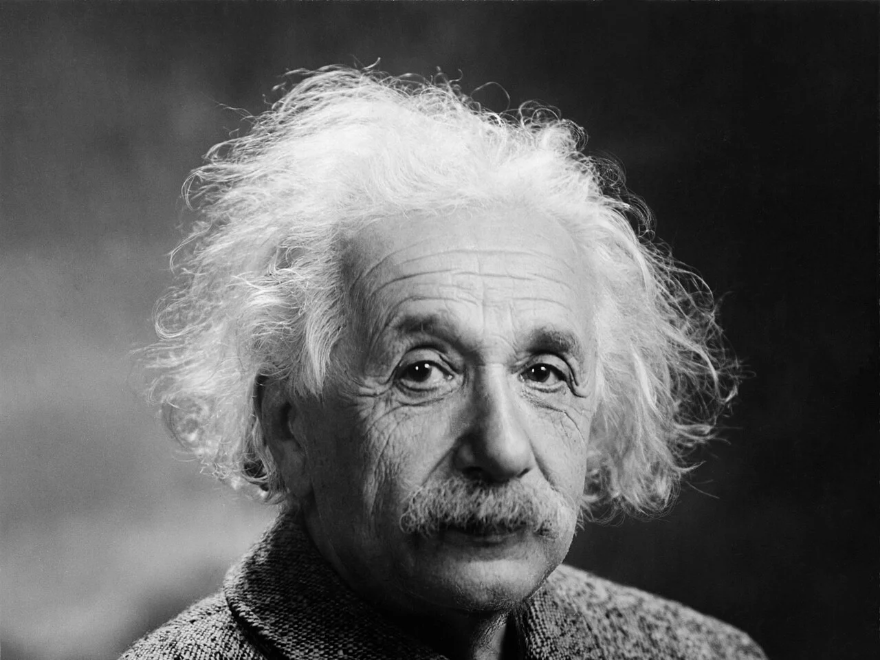 Svartvitt porträtt av Albert Einstein med vitt, yvigt hår och mustasch, fotograferad i Princeton 1947
